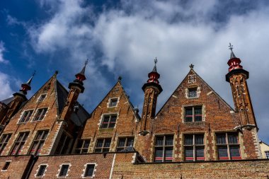 Belçika, Brugge 'deki evlerin çatısı ve kulesi mavi gökyüzü ile aydınlık bir yaz günü
