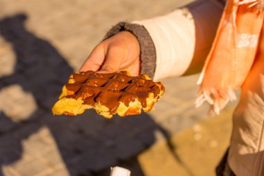 Belçika, Bruges, bir parça çikolatalı Belçika waffle 'ı tutan bir el.