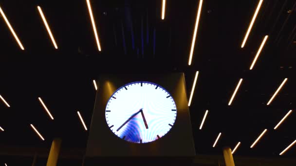 アムステルダムのスキポール空港オランダ 1月2019 時計の時間のために分の手を引く人を示す学校の空港で有名な時計の眺め — ストック動画