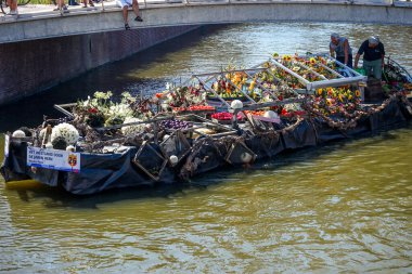 Hollanda, Delft-5 Ağustos 2018: Westland Boat Parade (Varend Corso), şenlikli gösteri, çiçek ve sebzelerle süslenmiş tekneler, Westland bölgesinde renkli yelkenli çiçek geçit töreni