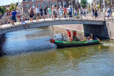 Hollanda, Delft-5 Ağustos 2018: Westland Boat Parade (Varend Corso), şenlikli gösteri, çiçek ve sebzelerle süslenmiş tekneler, Westland bölgesinde renkli yelkenli çiçek geçit töreni
