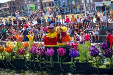 Hollanda, Delft-5 Ağustos 2018: Westland Boat Parade (Varend Corso), şenlikli gösteri, çiçek ve sebzelerle süslenmiş tekneler, Westland bölgesinde renkli yelkenli çiçek geçit töreni
