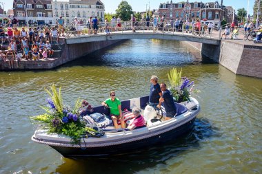 Hollanda, Delft-5 Ağustos 2018: Westland Boat Parade (Varend Corso), şenlikli gösteri, çiçek ve sebzelerle süslenmiş tekneler, Westland bölgesinde renkli yelkenli çiçek geçit töreni