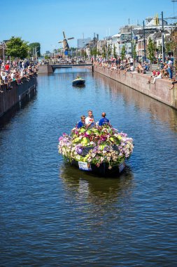 Hollanda, Delft-5 Ağustos 2018: Westland Boat Parade (Varend Corso), şenlikli gösteri, çiçek ve sebzelerle süslenmiş tekneler, Westland bölgesinde renkli yelkenli çiçek geçit töreni