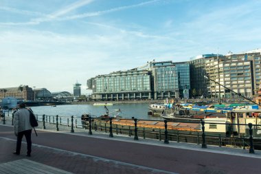 Hollanda, Amsterdam - 21 Nisan 2017: Amsterdam Kanalı yakınında yürüyen kişi