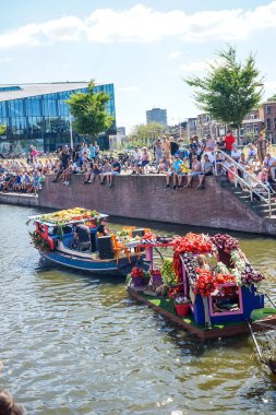 Hollanda, Delft-5 Ağustos 2018: Westland Boat Parade (Varend Corso), şenlikli gösteri, çiçek ve sebzelerle süslenmiş tekneler, Westland bölgesinde renkli yelkenli çiçek geçit töreni