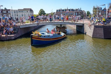 Hollanda, Delft-5 Ağustos 2018: Westland Boat Parade (Varend Corso), şenlikli gösteri, çiçek ve sebzelerle süslenmiş tekneler, Westland bölgesinde renkli yelkenli çiçek geçit töreni