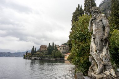Varenna, İtalya - 31 Mart 2018: Güneşli bir yaz gününde Varenna 'daki güzel Villa Manastırı' na bakan bir heykel. Como Gölü, Lombardy, İtalya