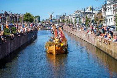 Hollanda, Delft-5 Ağustos 2018: Westland Boat Parade (Varend Corso), şenlikli gösteri, çiçek ve sebzelerle süslenmiş tekneler, Westland bölgesinde renkli yelkenli çiçek geçit töreni