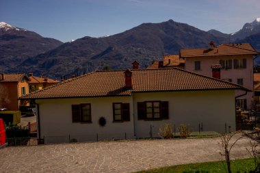 Menaggio, İtalya-2 Nisan 2018: Menaggio, Lombardy 'de arka planda dağ olan taş bir bina manzarası