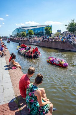 Hollanda, Delft-5 Ağustos 2018: Westland Boat Parade (Varend Corso), şenlikli gösteri, çiçek ve sebzelerle süslenmiş tekneler, Westland bölgesinde renkli yelkenli çiçek geçit töreni