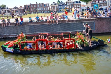 Hollanda, Delft-5 Ağustos 2018: Westland Boat Parade (Varend Corso), şenlikli gösteri, çiçek ve sebzelerle süslenmiş tekneler, Westland bölgesinde renkli yelkenli çiçek geçit töreni