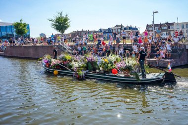 Hollanda, Delft-5 Ağustos 2018: Westland Boat Parade (Varend Corso), şenlikli gösteri, çiçek ve sebzelerle süslenmiş tekneler, Westland bölgesinde renkli yelkenli çiçek geçit töreni