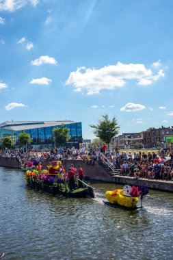 Hollanda, Delft-5 Ağustos 2018: Westland Boat Parade (Varend Corso), şenlikli gösteri, çiçek ve sebzelerle süslenmiş tekneler, Westland bölgesinde renkli yelkenli çiçek geçit töreni