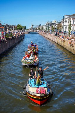 Hollanda, Delft-5 Ağustos 2018: Westland Boat Parade (Varend Corso), şenlikli gösteri, çiçek ve sebzelerle süslenmiş tekneler, Westland bölgesinde renkli yelkenli çiçek geçit töreni