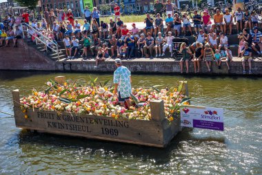 Hollanda, Delft-5 Ağustos 2018: Westland Boat Parade (Varend Corso), şenlikli gösteri, çiçek ve sebzelerle süslenmiş tekneler, Westland bölgesinde renkli yelkenli çiçek geçit töreni