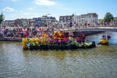 Hollanda, Delft-5 Ağustos 2018: Westland Boat Parade (Varend Corso), şenlikli gösteri, çiçek ve sebzelerle süslenmiş tekneler, Westland bölgesinde renkli yelkenli çiçek geçit töreni
