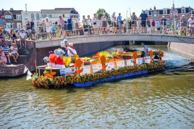 Hollanda, Delft-5 Ağustos 2018: Westland Boat Parade (Varend Corso), şenlikli gösteri, çiçek ve sebzelerle süslenmiş tekneler, Westland bölgesinde renkli yelkenli çiçek geçit töreni