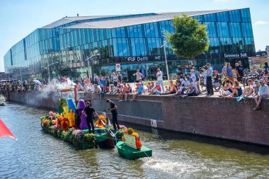 Hollanda, Delft-5 Ağustos 2018: Westland Boat Parade (Varend Corso), şenlikli gösteri, çiçek ve sebzelerle süslenmiş tekneler, Westland bölgesinde renkli yelkenli çiçek geçit töreni