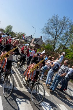 Hollanda, Sassenheim-21 Nisan 2018: Bulbflower Parade 2018, Bloemencorso BollenStreek, şenlikli gösteri, çiçeklerle süslenmiş araçlar, baharın yüzü, Ulusal Hollanda çiçek geçidi, bisikletli saksafon
