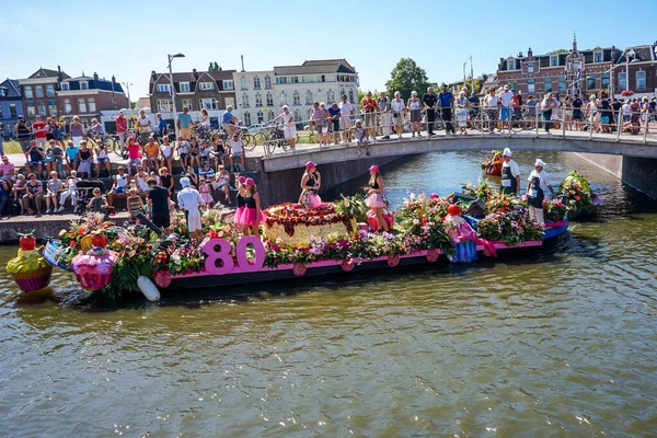 Hollanda, Delft-5 Ağustos 2018: Westland Boat Parade (Varend Corso), şenlikli gösteri, çiçek ve sebzelerle süslenmiş tekneler, Westland bölgesinde renkli yelkenli çiçek geçit töreni