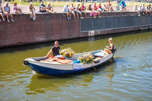 Hollanda, Delft-5 Ağustos 2018: Westland Boat Parade (Varend Corso), şenlikli gösteri, çiçek ve sebzelerle süslenmiş tekneler, Westland bölgesinde renkli yelkenli çiçek geçit töreni