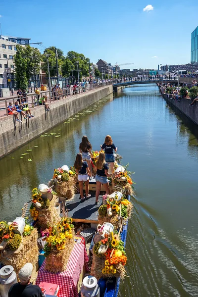Hollanda, Delft-5 Ağustos 2018: Westland Boat Parade (Varend Corso), şenlikli gösteri, çiçek ve sebzelerle süslenmiş tekneler, Westland bölgesinde renkli yelkenli çiçek geçit töreni