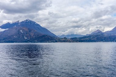 Avrupa, İtalya, Varenna, Como Gölü. Arkasında dağ olan büyük bir su kütlesi.
