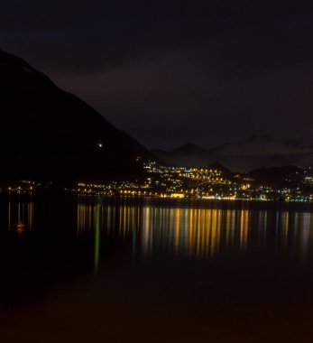 Avrupa, İtalya, Varenna, Como Gölü. Gece vakti bir su kütlesinin önündeki şehir manzarası.