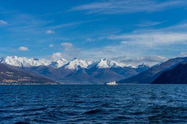 İtalya, Bellagio, Como Gölü 'nde karla kaplı arka planı olan bir tekne.