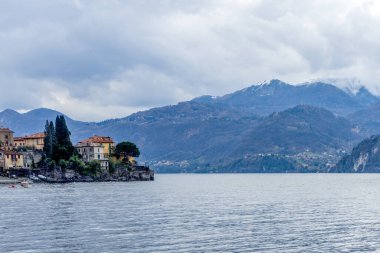 Avrupa, İtalya, Varenna, Como Gölü. Arkasında dağ olan büyük bir su kütlesi.