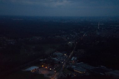 Uçak penceresinden bulutların görüntüsü, gece vakti şehrin yüksek açılı binalarının görüntüsü.