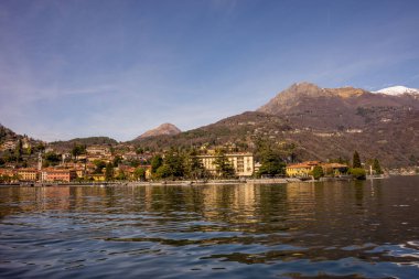 Avrupa, İtalya, Menaggio, Como Gölü. Arkasında dağ olan büyük bir su kütlesi.