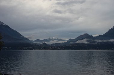 Avrupa, İtalya, Varenna, Como Gölü. Arkasında dağ olan büyük bir su kütlesi.