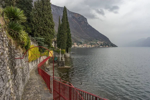 ヨーロッパ イタリア バレンナ コモ湖 バックグラウンドで山と水のボディ上の橋 — ストック写真