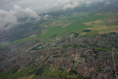 Hollanda, Hollanda 'da bulutlu, yeşil tarlalı, gökyüzünde kanalı olan çiftlikler.