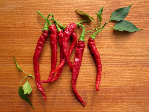 Chili peppers on wooden background — Stock Photo, Image