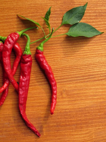 Chili peppers on wooden background — Stock Photo, Image