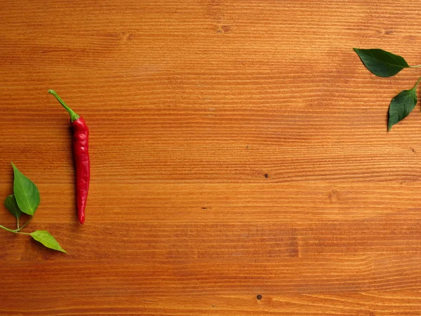 Chili peppers on wooden background — Stock Photo, Image
