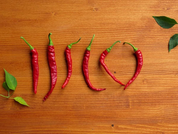 Chili peppers on wooden background — Stock Photo, Image