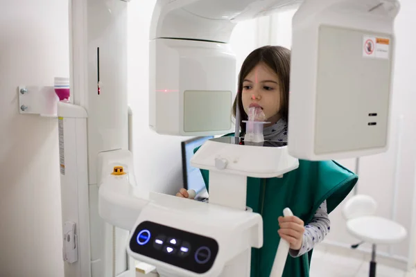 Tıp, dişçilik ve sağlık sigortası konsepti. Diş kliniğinde çocuğun dişlerini tarayan röntgen cihazı..