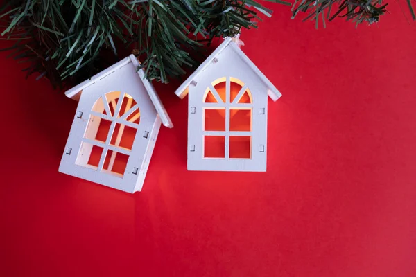 Kırmızı arka planda parlayan ahşap evler, yeni yıl ve noel konsepti.