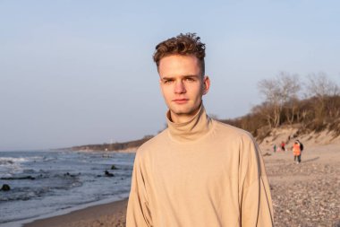 Genç bir delikanlının portresi denizin arka planında.