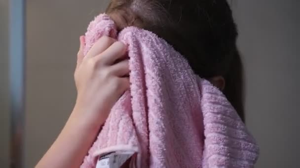 Menina limpa o rosto com uma toalha no banheiro depois de lavar o rosto — Vídeo de Stock