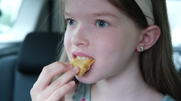 Kislány eszik csirkefalatokat a kocsiban, gyorskaja — Stock videók