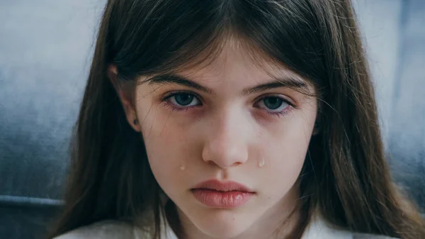 Retrato de uma menina bonita triste com olhos azuis e lágrimas em suas bochechas — Fotografia de Stock