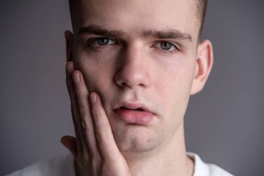 Suratı Tutan Üzgün Genç Adam. diş ağrısı