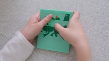 Küçük çocuk bulmaca oyunu topluyor, yakın plan.