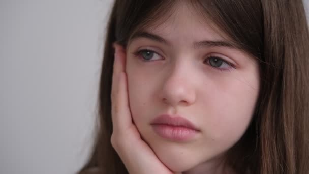 Πορτρέτο ενός θλιμμένου όμορφου κοριτσιού με μπλε μάτια, έφηβος κλαίει, κρατώντας το κεφάλι του — Αρχείο Βίντεο
