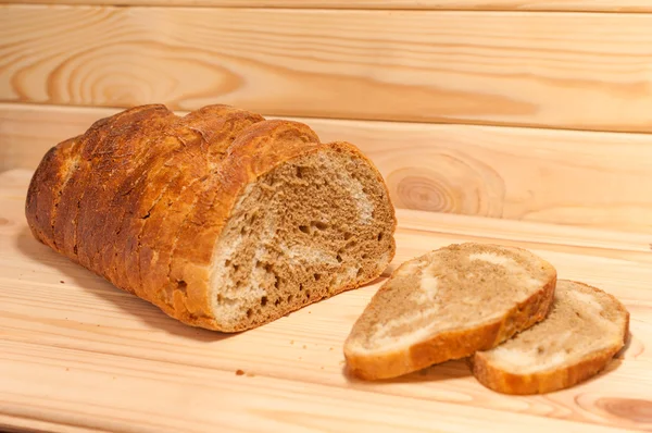 Trigo cortado em mármore pão de centeio em uma tábua de madeira — Fotografia de Stock